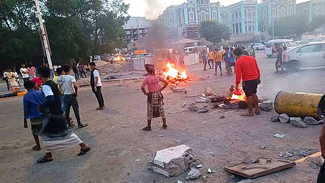 محتجون بعدن يقطعون طريق قصر معاشيق بإشعال الإطارات والأحجار